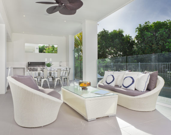 Luxurious undercover patio with couches, barbeque and dining area